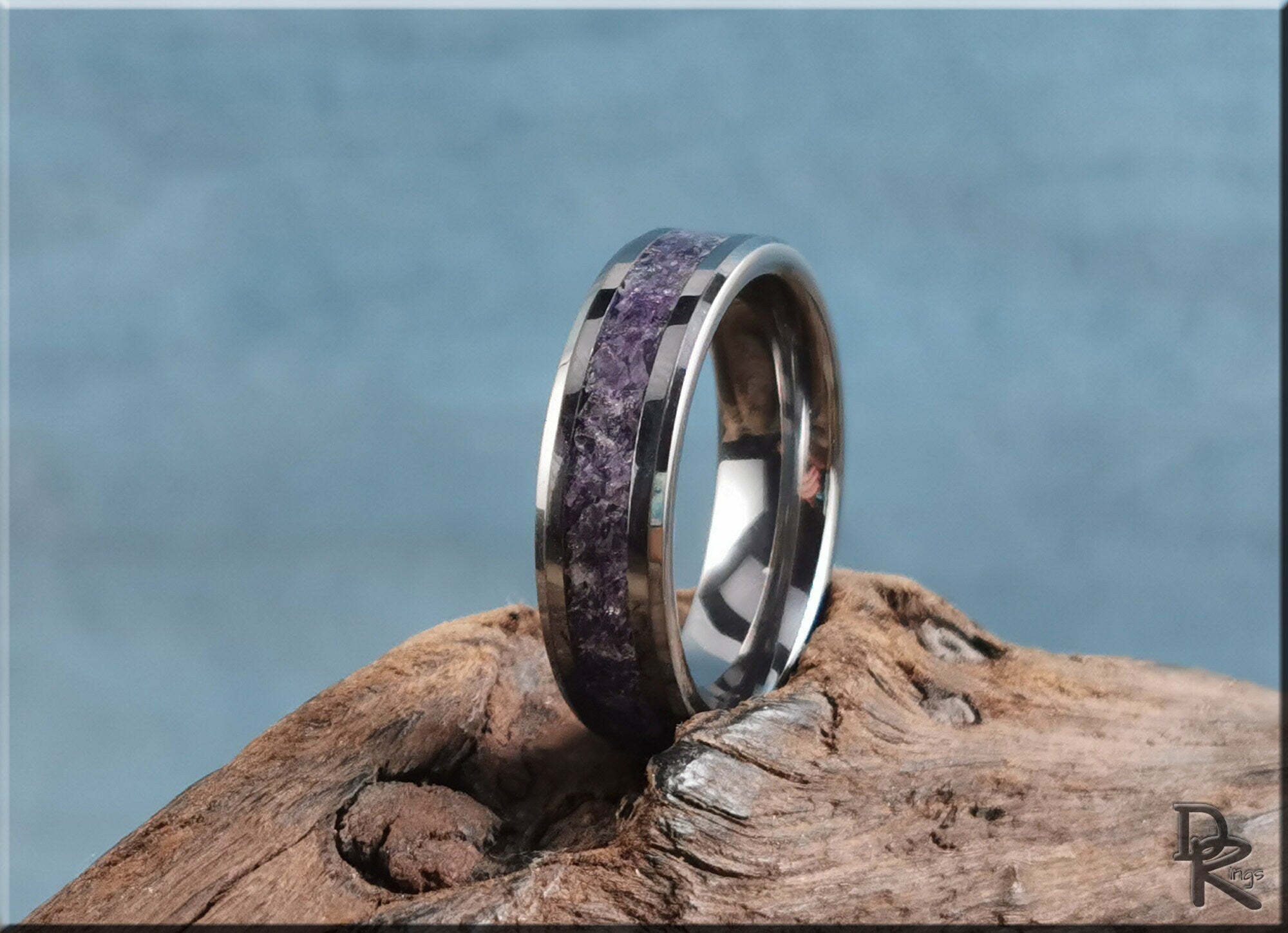 DR Rings tungsten ring with amethyst inlay on natural wooden surface with blue background