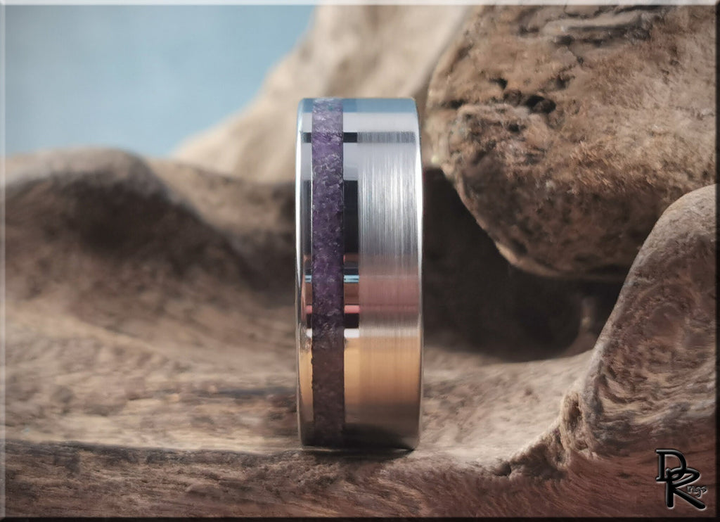 DR Rings tungsten ring with amethyst inlay set on textured natural stone background