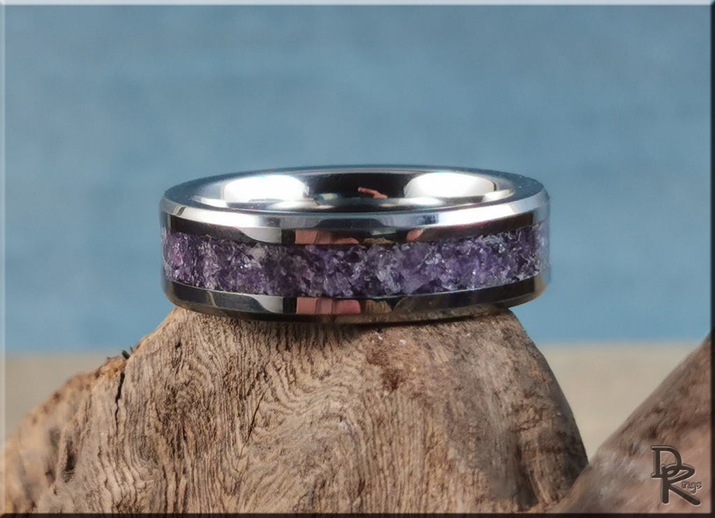 DR Rings tungsten ring with amethyst inlay featuring crushed purple gemstones on wood background