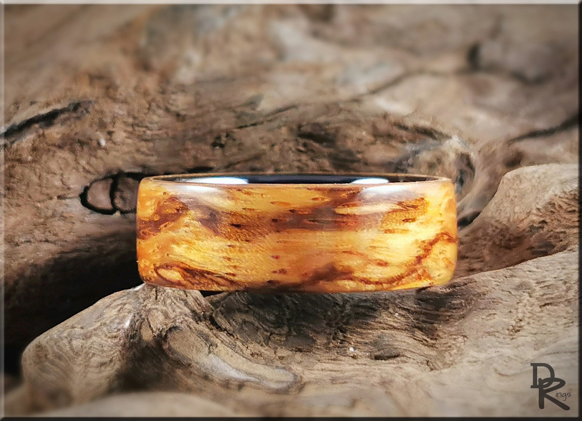 Wood ring on ceramic core with natural wood grain pattern displayed on rustic wood background