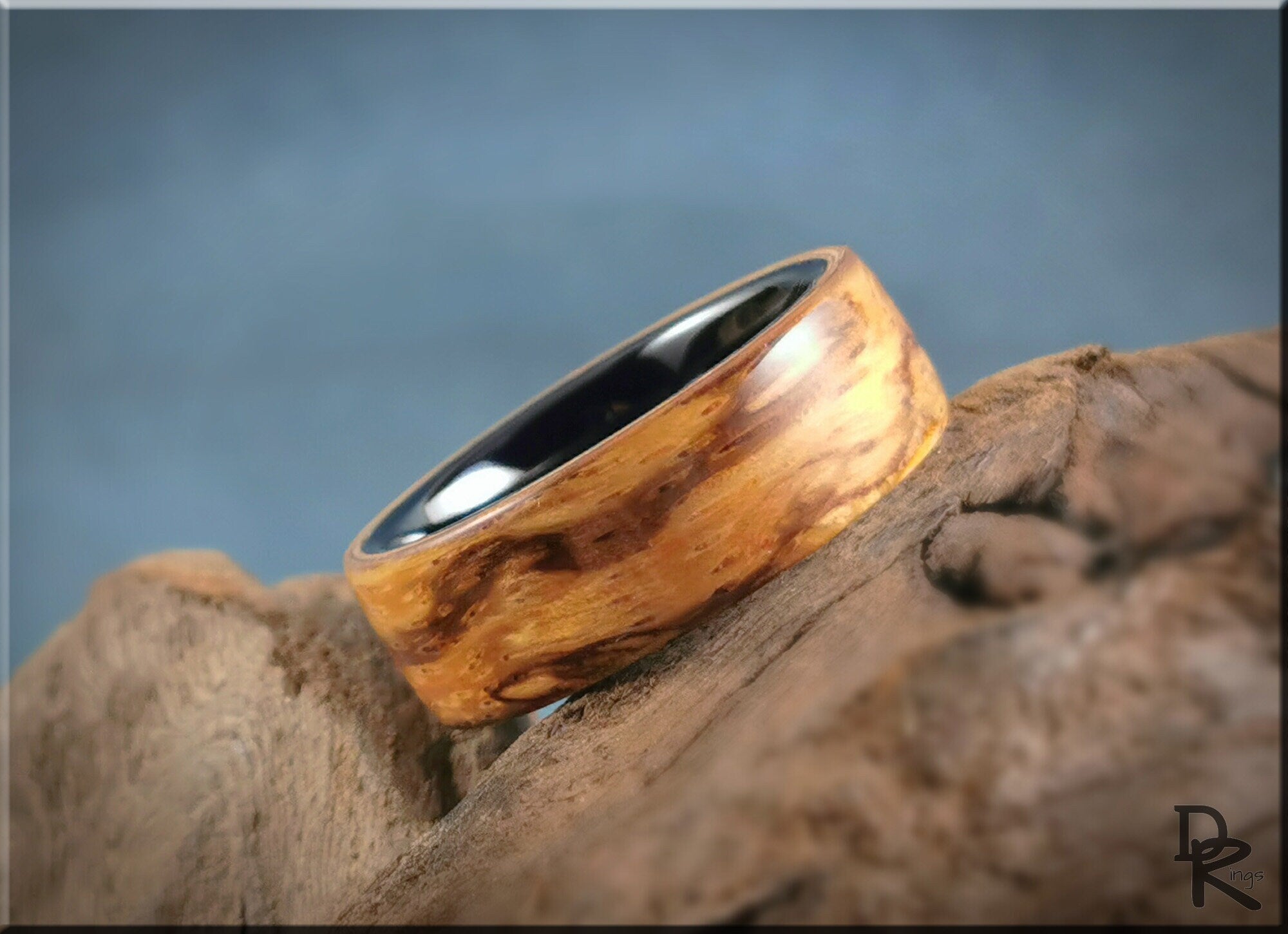 Wood ring on ceramic core by DR Rings with natural wood grain and smooth black ceramic interior