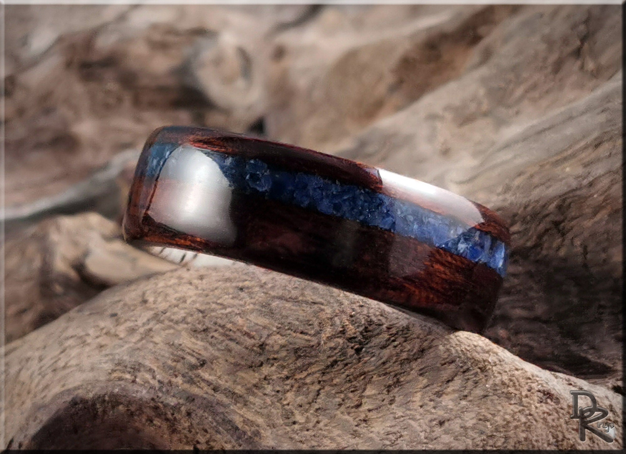 DR Rings wood ring with inlay featuring dark wood and blue stone detail on rustic background