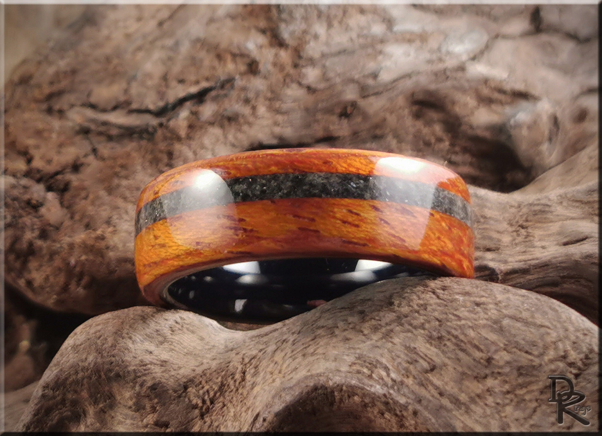 DR Rings wood ring with inlay featuring a polished wooden band with a dark stripe inlay on rustic wood background