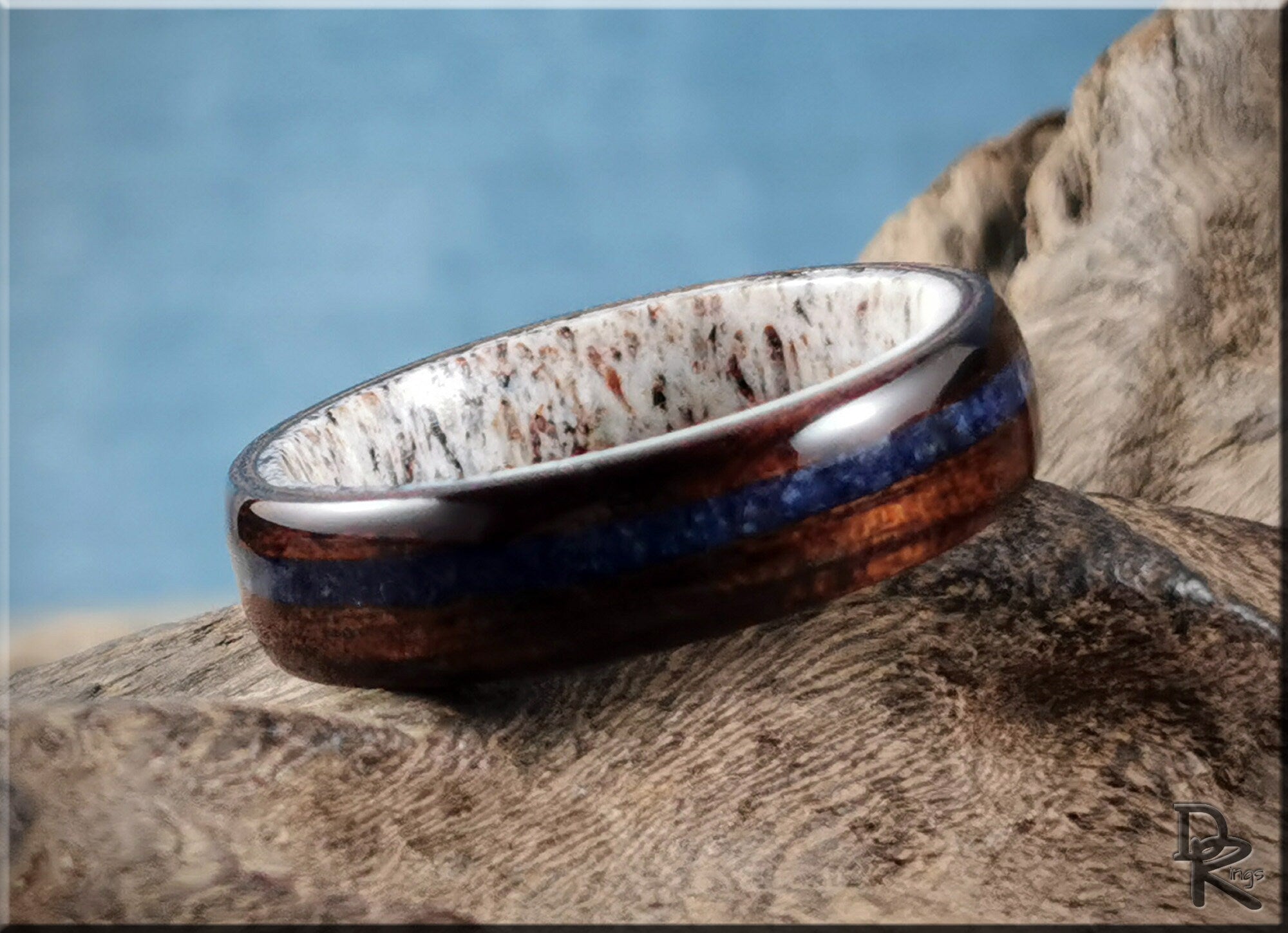 DR Rings wood ring with inlay featuring a rich brown wood and blue inlay design on natural background