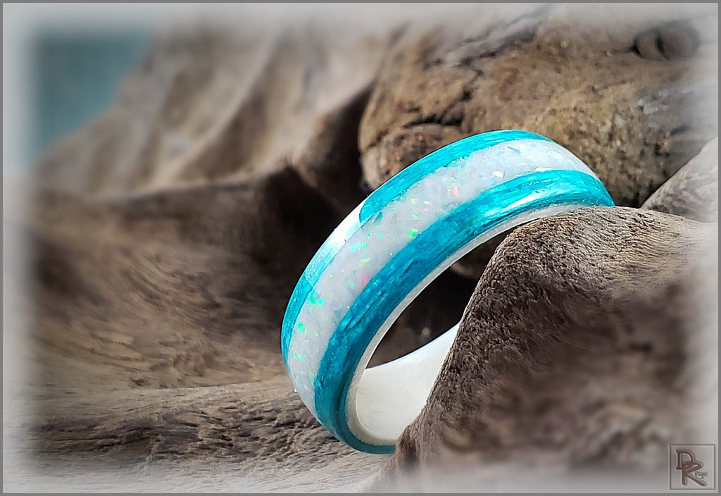 DR Rings wood ring with opal inlay featuring vibrant blue edges on a natural wooden background