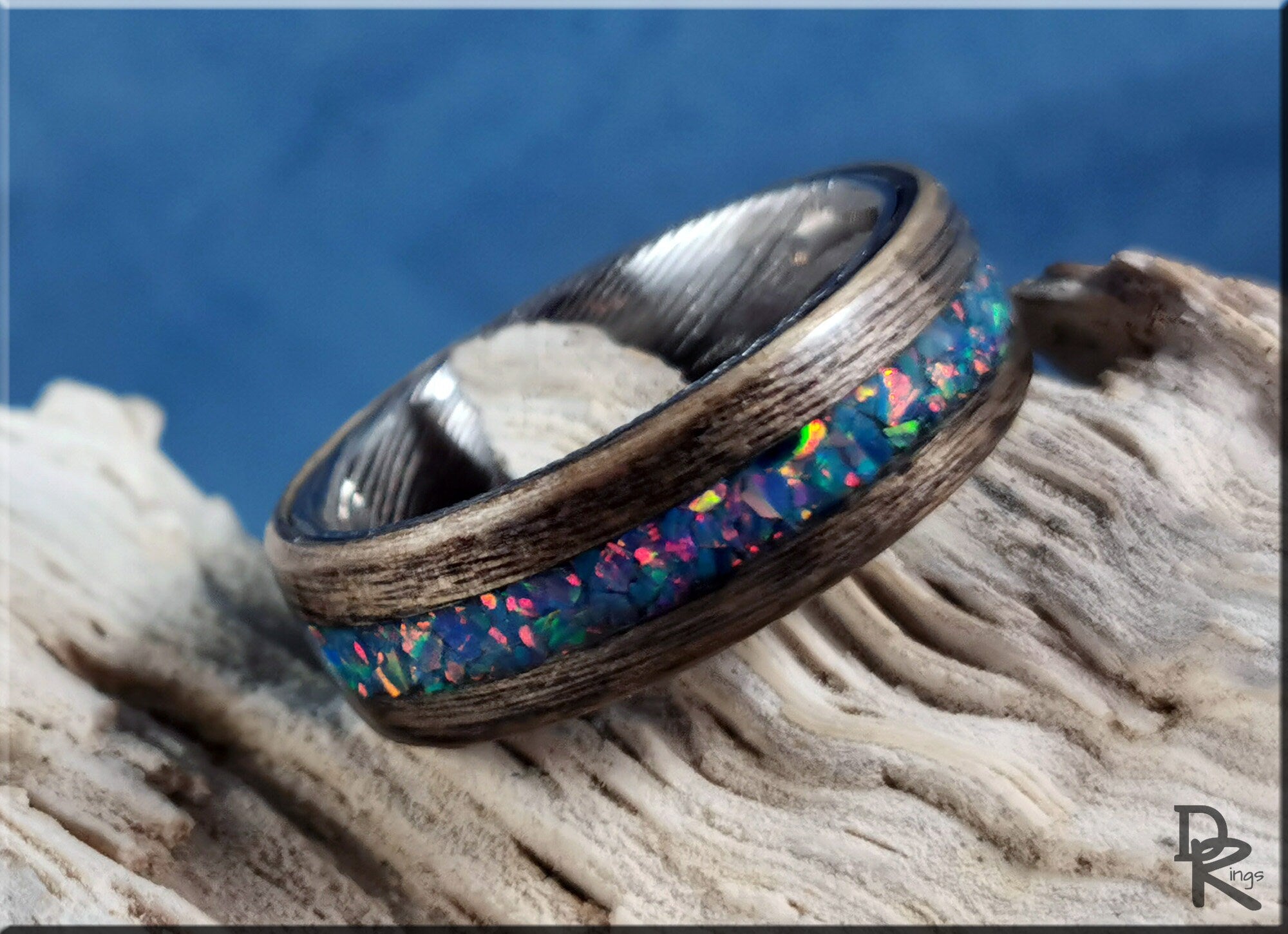Wood ring with opal inlay featuring colorful iridescent stones set in a natural wood band