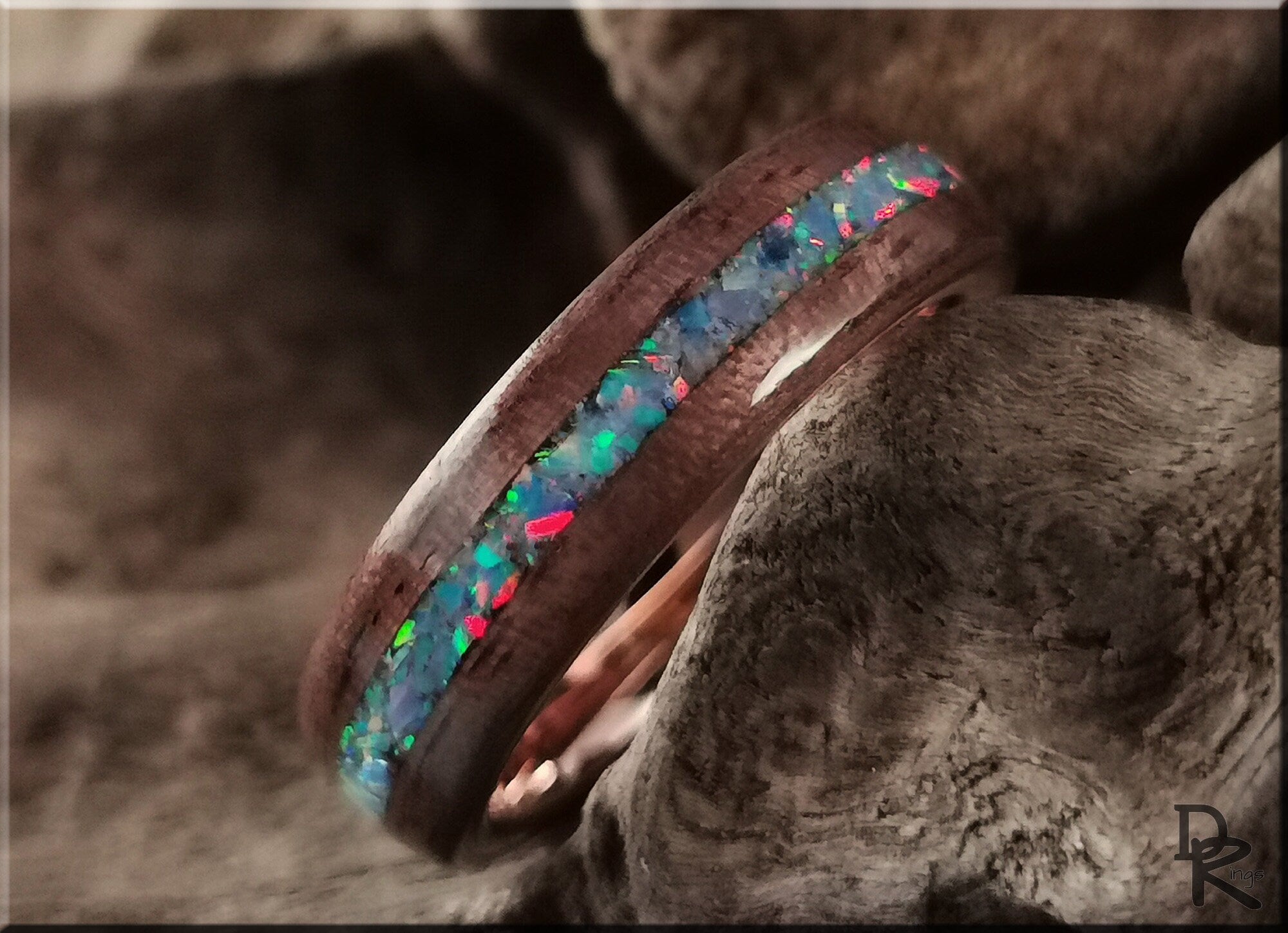 Wood ring with opal inlay featuring vibrant blue and green opal colors set in a smooth wooden band