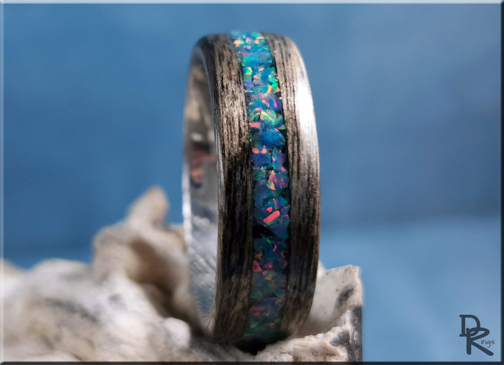 Wood ring with opal inlay featuring vibrant blue and green opal stones embedded in dark wood band