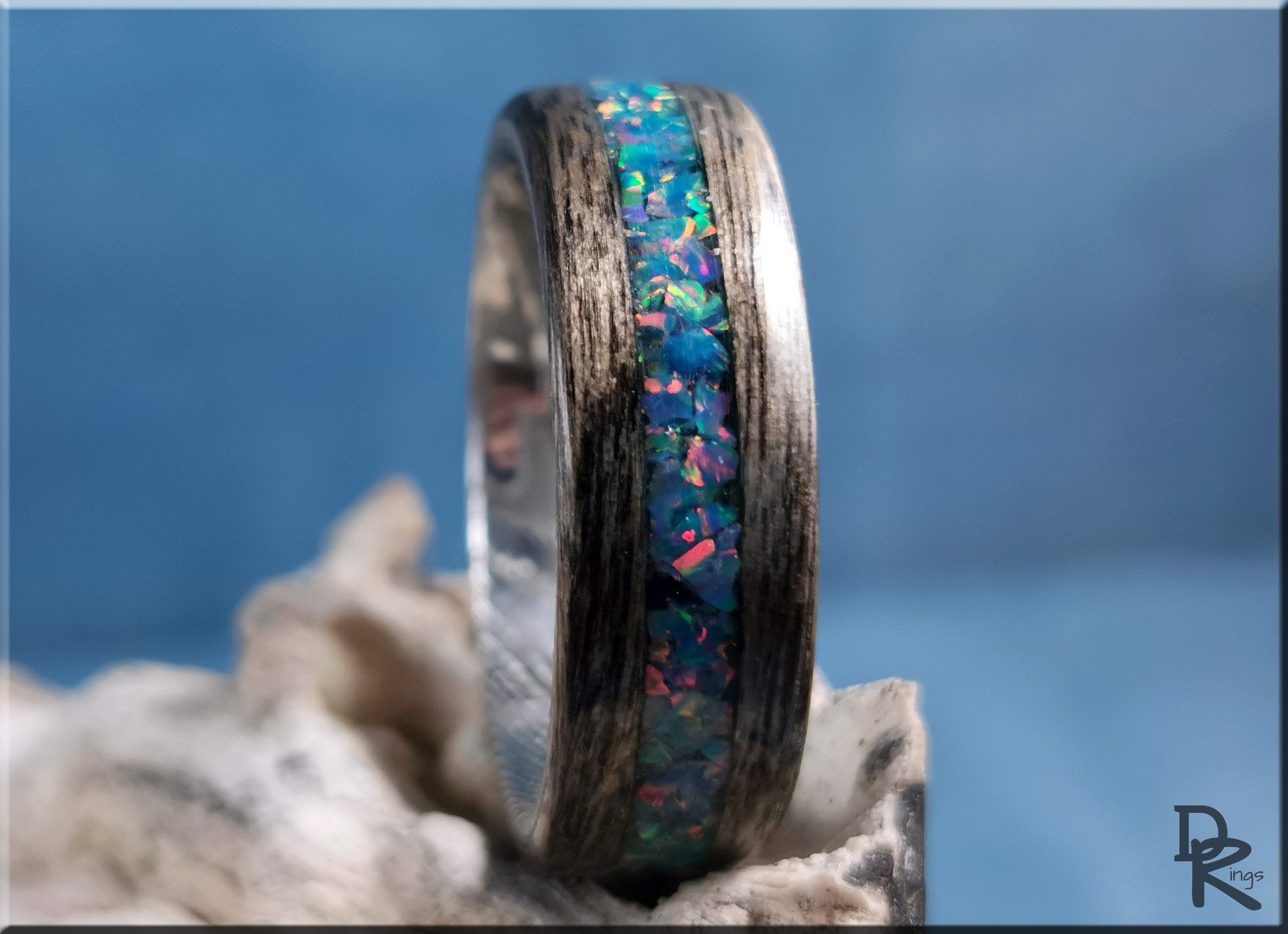 Wood ring with opal inlay featuring vibrant blue and green opal stones embedded in dark wood band