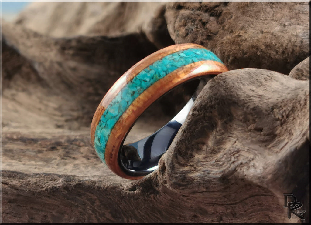 DR Rings wood ring with stone inlay featuring turquoise stones and polished wood band on rustic wood background