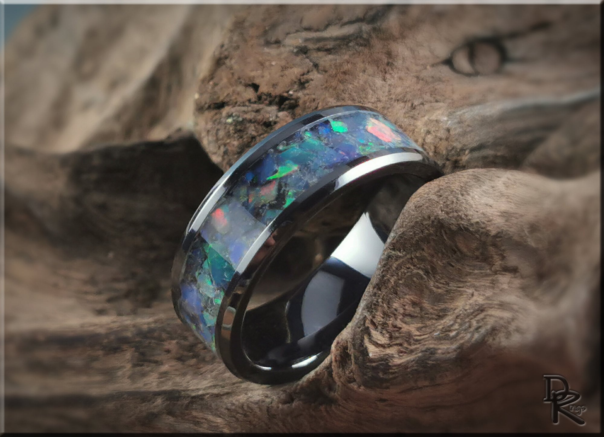 Black ceramic ring with opal inlay featuring vibrant blue and green colors by DR Rings