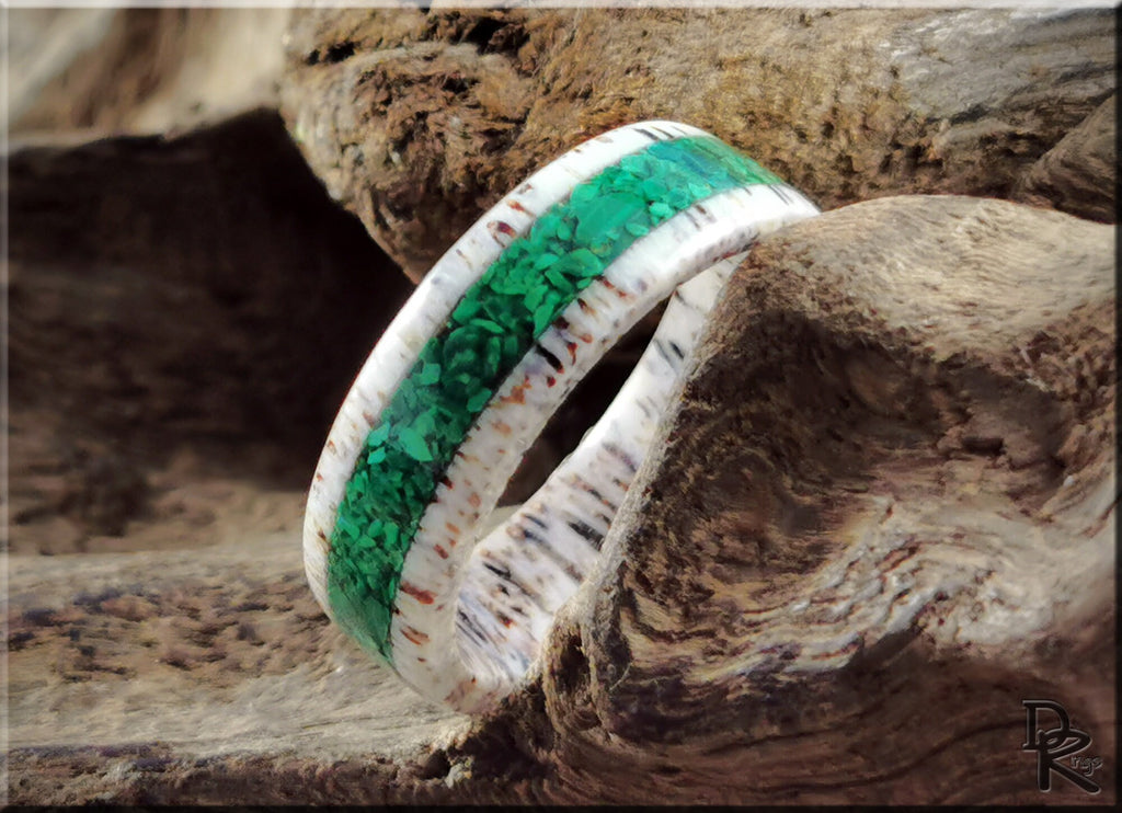 DR Rings antler ring with green resin inlay showcasing unique natural patterns on wood background