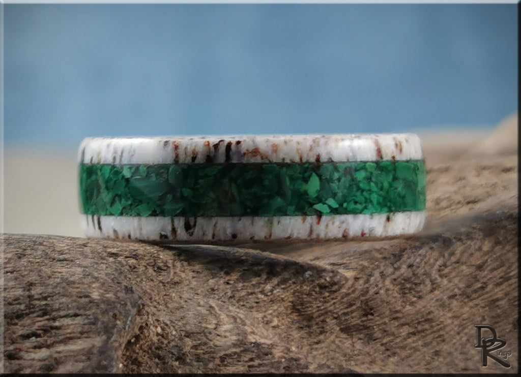 DR Rings antler ring with green inlay and white textured edges on rustic wood background