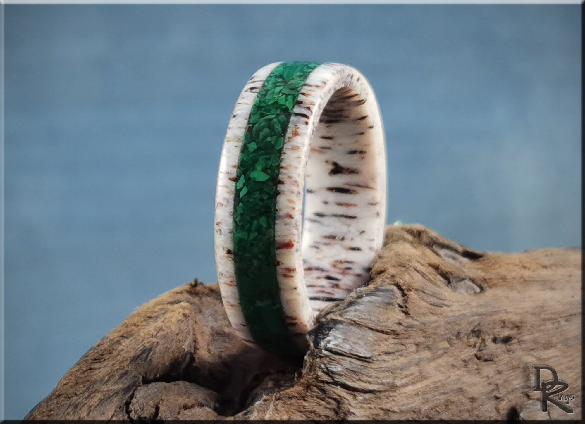 DR Rings antler ring with green inlay displayed on natural wood background