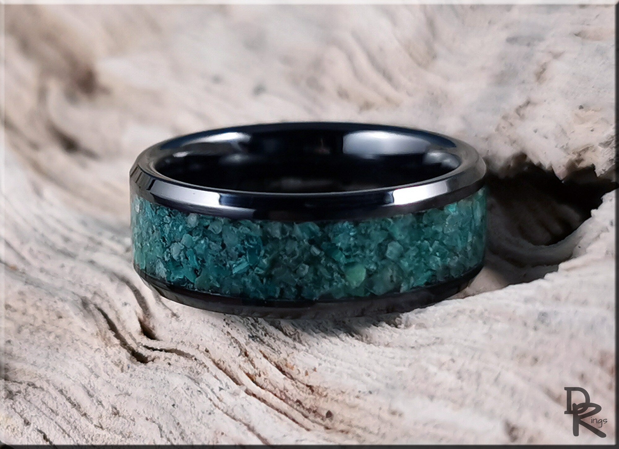 Black ceramic ring with inlay of green crushed stone texture by DR Rings on wood background
