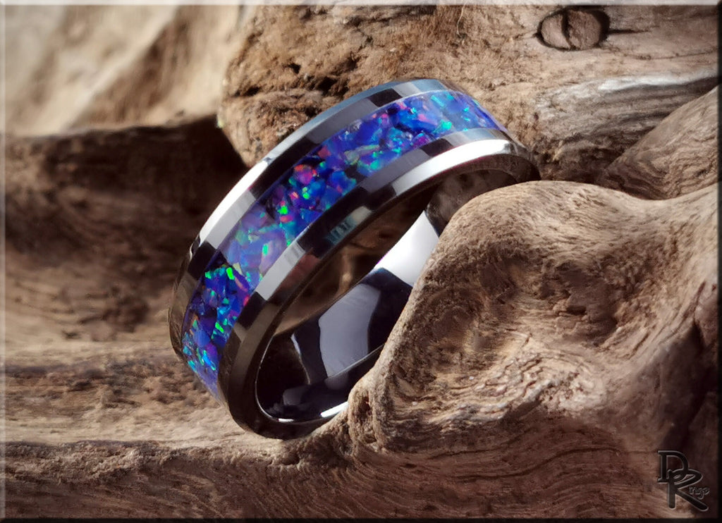 Ceramic ring with opal inlay featuring vibrant blue and green tones by DR Rings on rustic wood