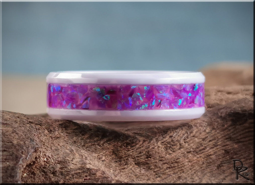 DR Rings white ceramic ring with opal featuring vibrant purple and blue inlay on textured wood background