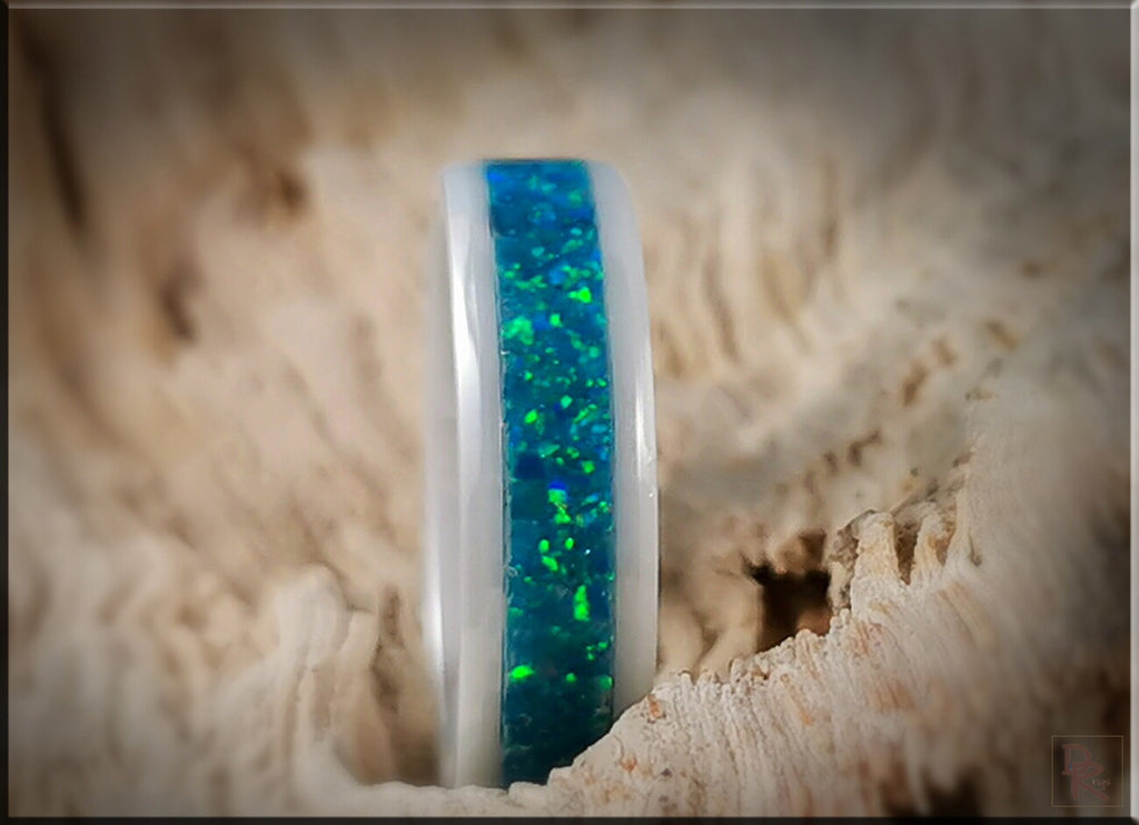 White ceramic ring with opal inlay featuring blue and green sparkling stones