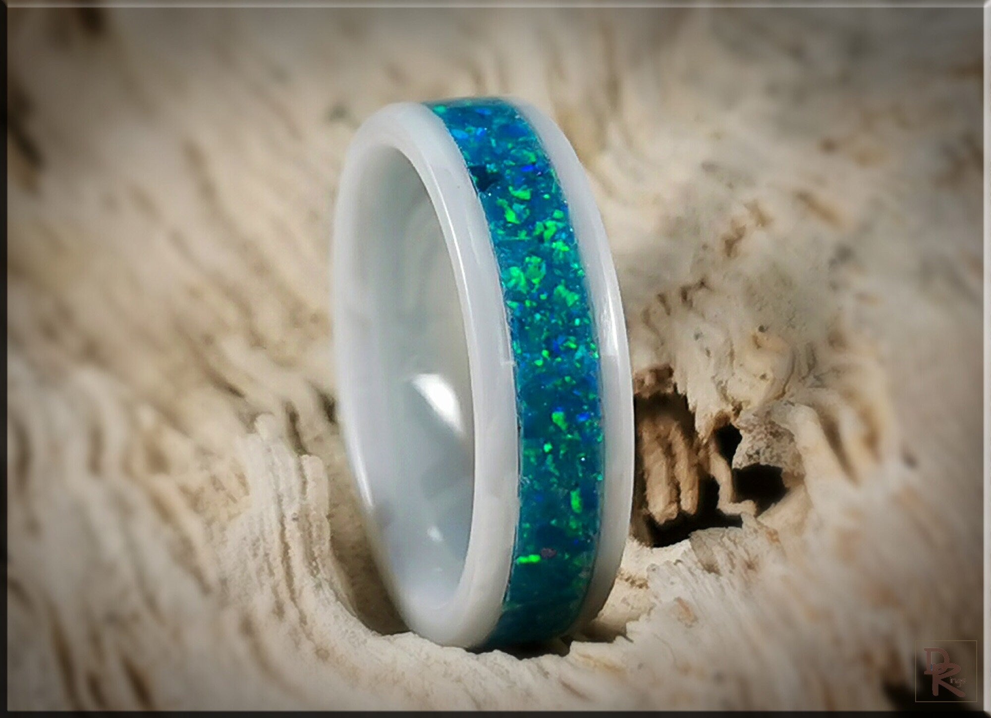 White ceramic ring with opal inlay featuring vibrant blue and green colors by DR Rings