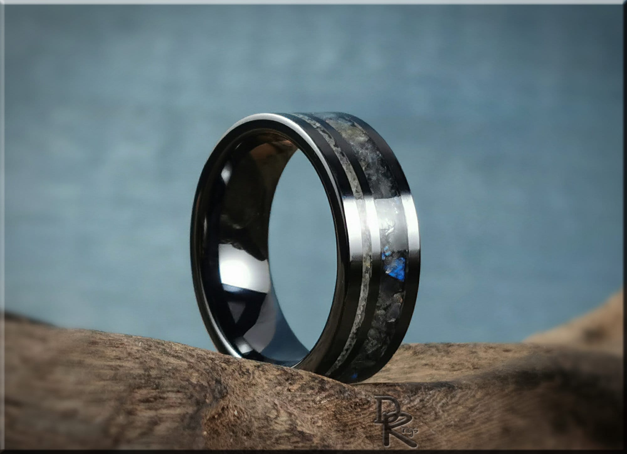 DR Rings black ceramic ring with dual inlays featuring a sleek modern design on a natural wood surface