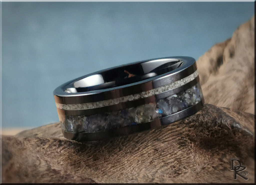 Black ceramic ring with dual inlays featuring a polished finish and intricate stone details
