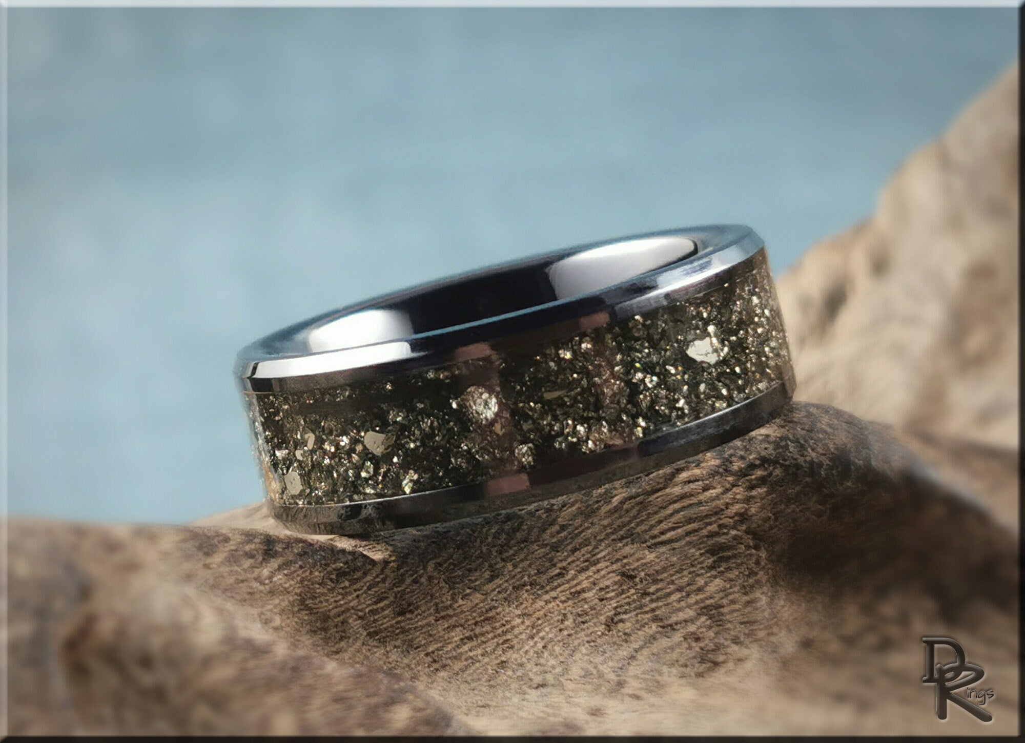 DR Rings ceramic ring with pyrite inlay featuring metallic gold flakes on a polished black band