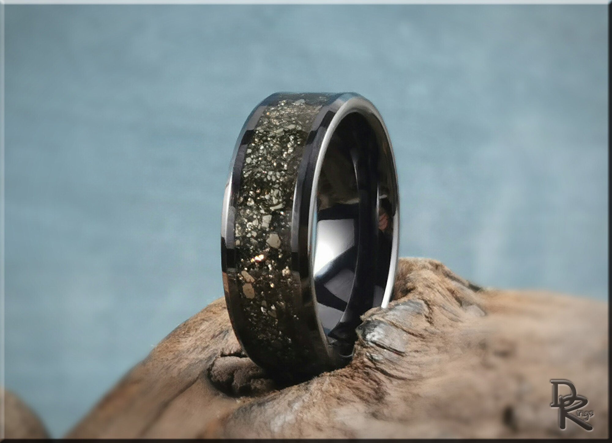 DR Rings ceramic ring with pyrite embedded in glossy black band displayed on natural wood