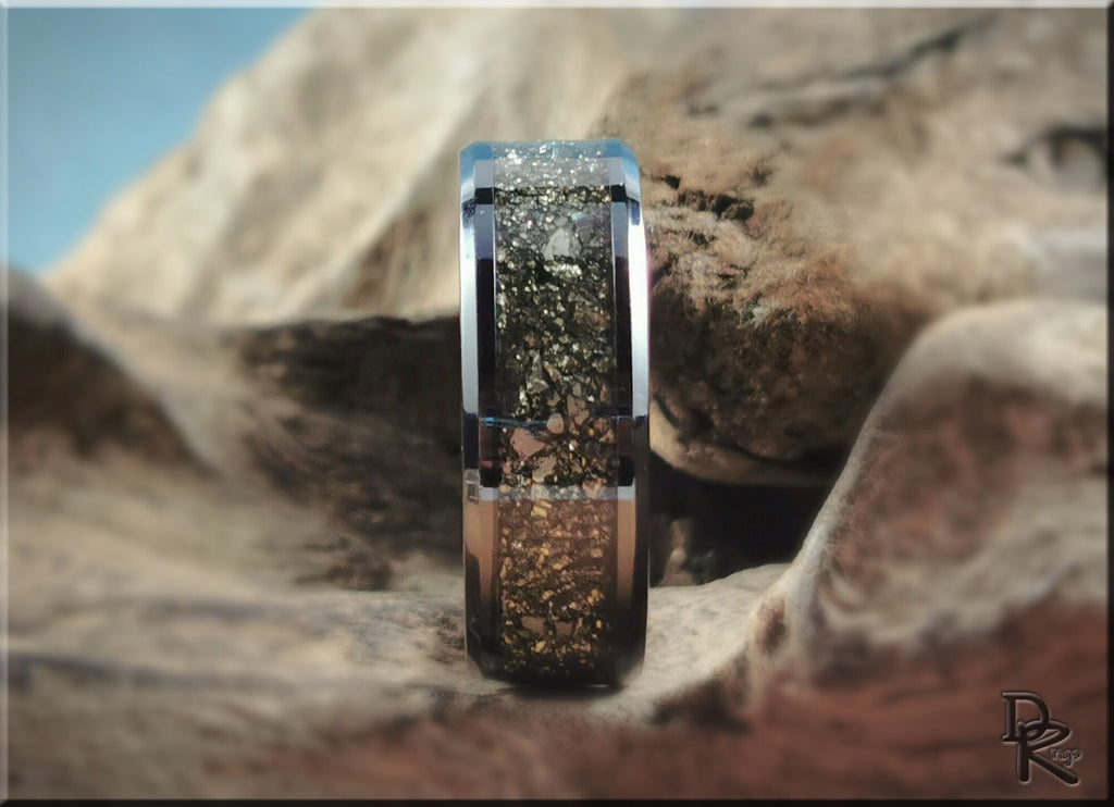 DR Rings ceramic ring with pyrite embedded in a polished black band displayed on natural rock