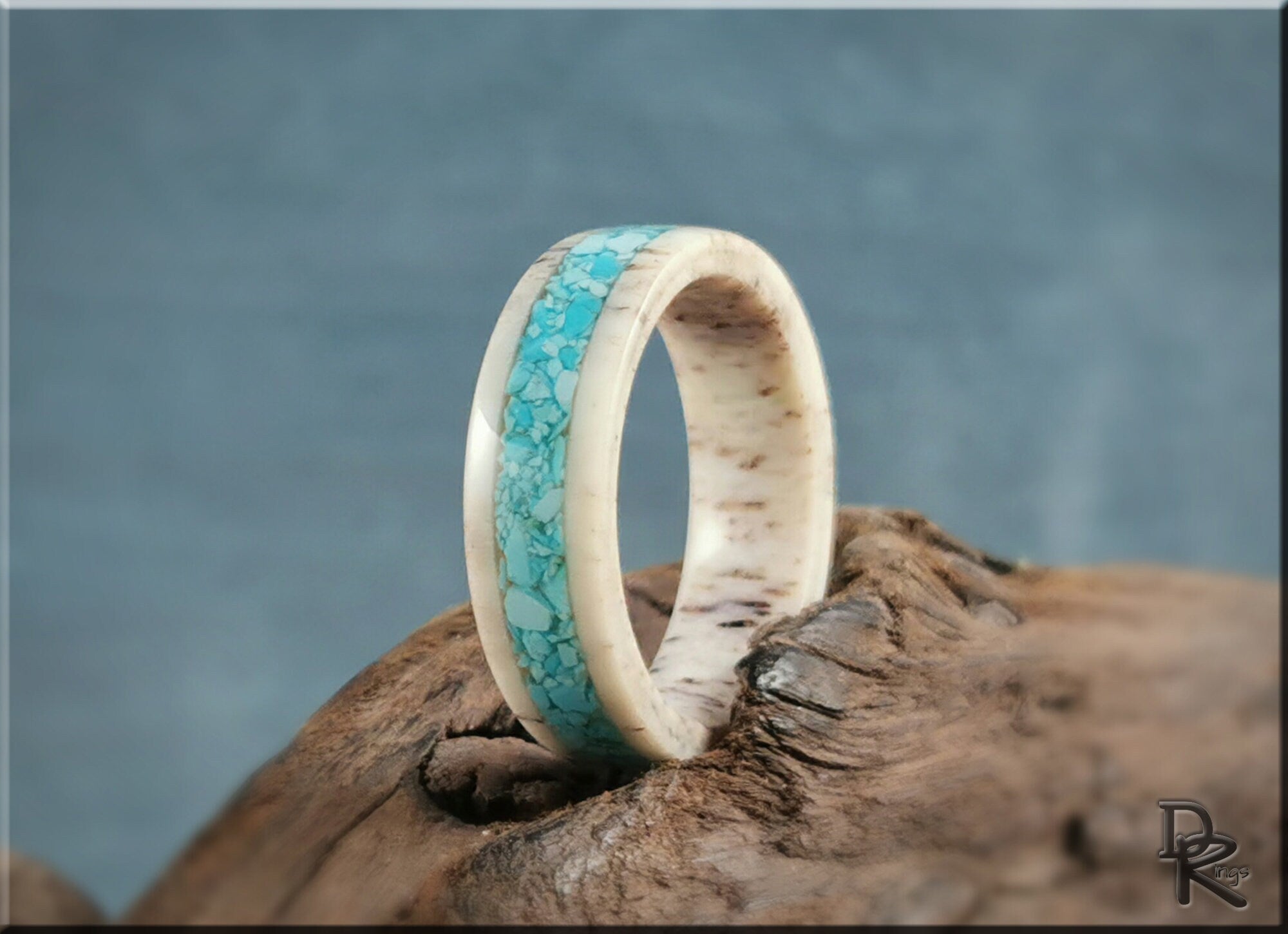 Deer antler ring with turquoise inlay by DR Rings on rustic wooden surface