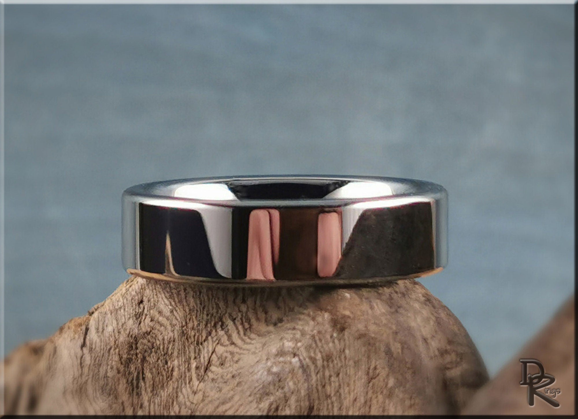 DR Rings polished tungsten ring carbide with smooth reflective surface on wooden display