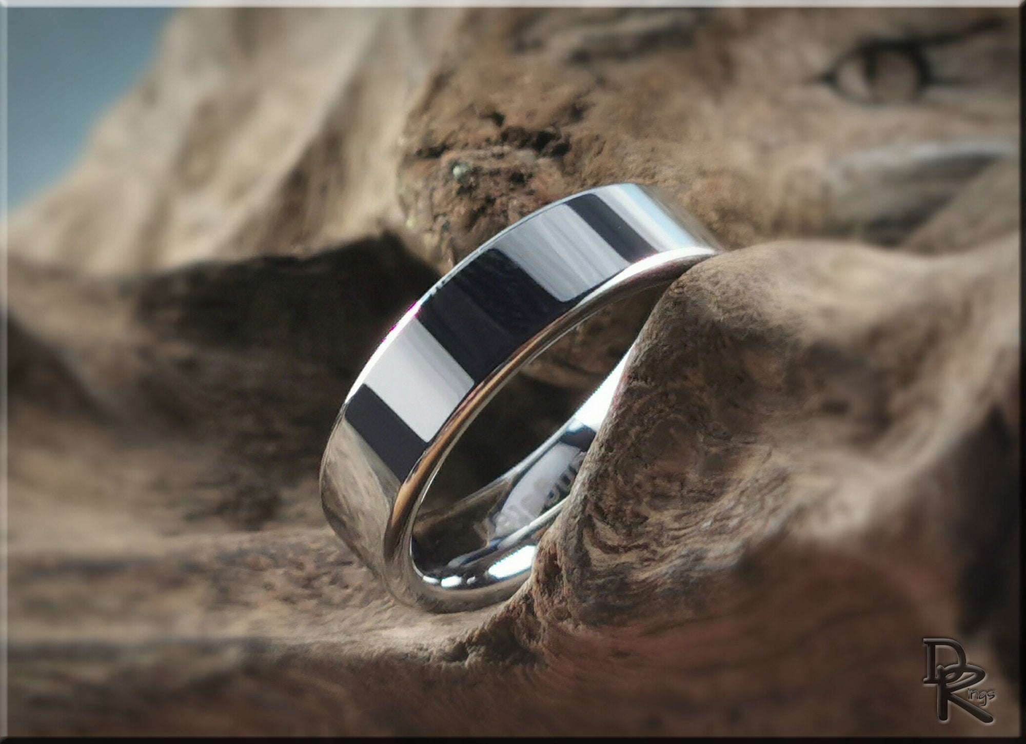 DR Rings polished silver tungsten ring carbide with a sleek design on natural wood background