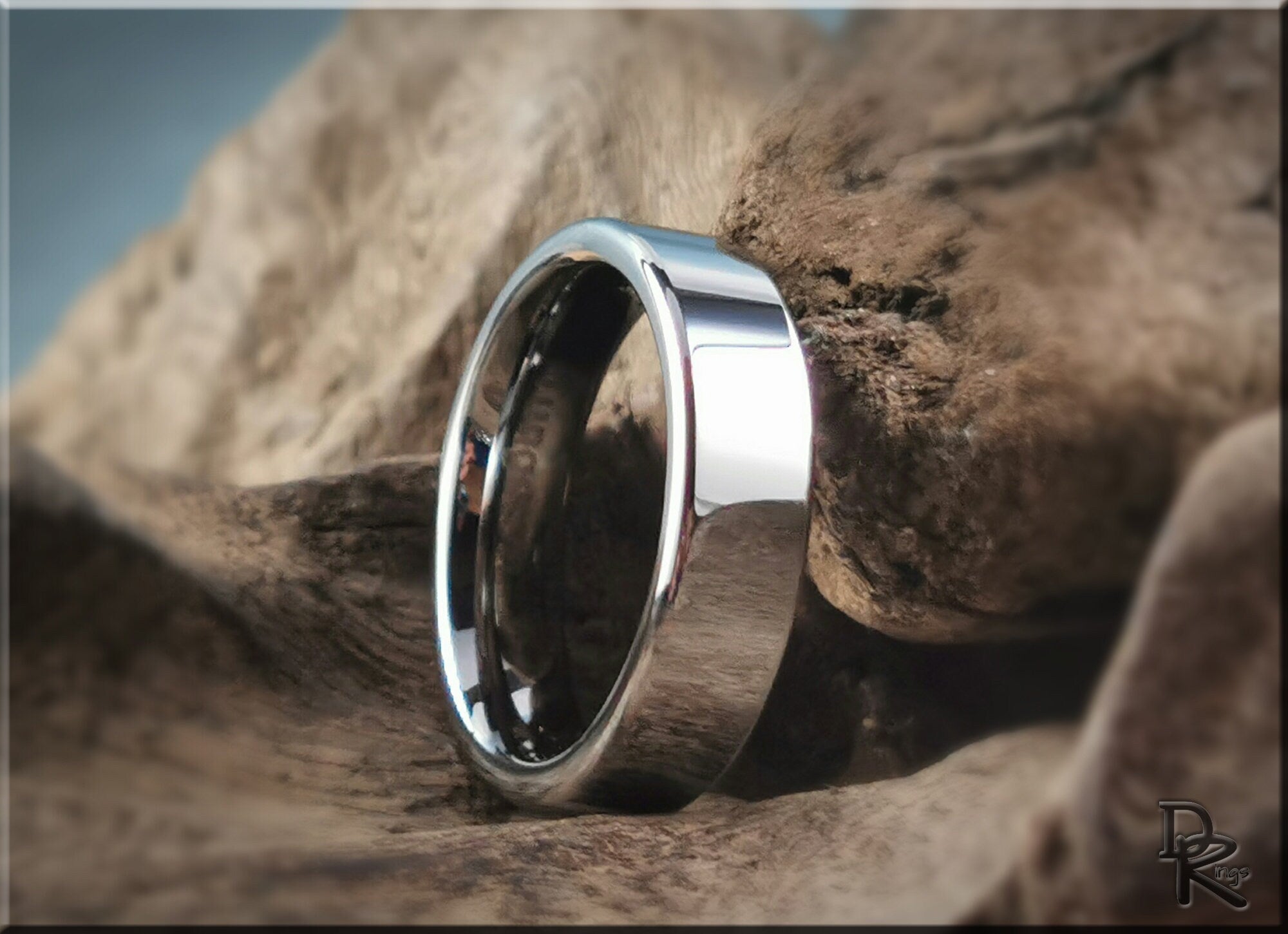 DR Rings polished tungsten ring carbide with a reflective smooth surface on natural wood background