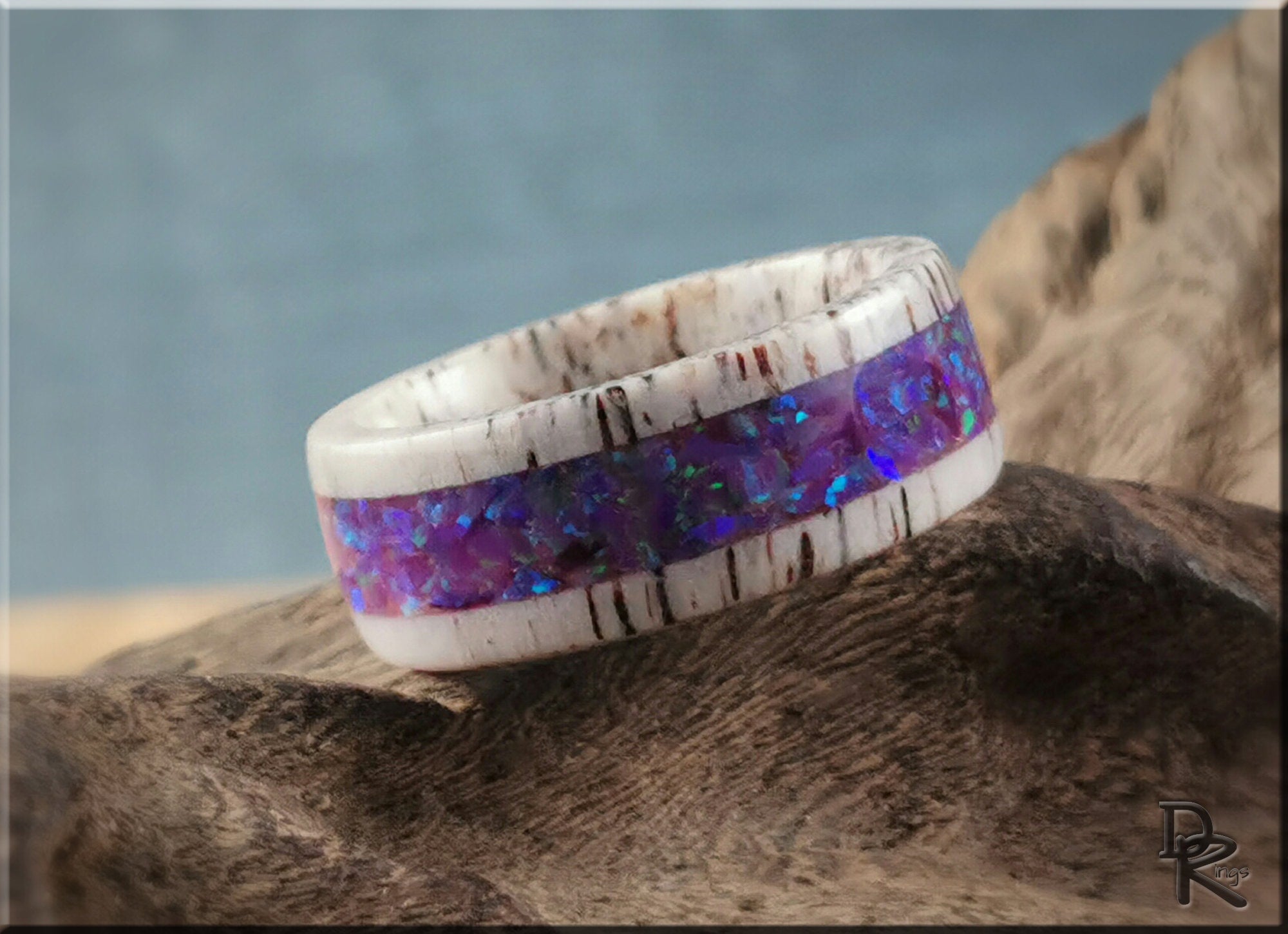 Deer antler ring with opal inlay featuring a white antler band and vibrant blue opal center