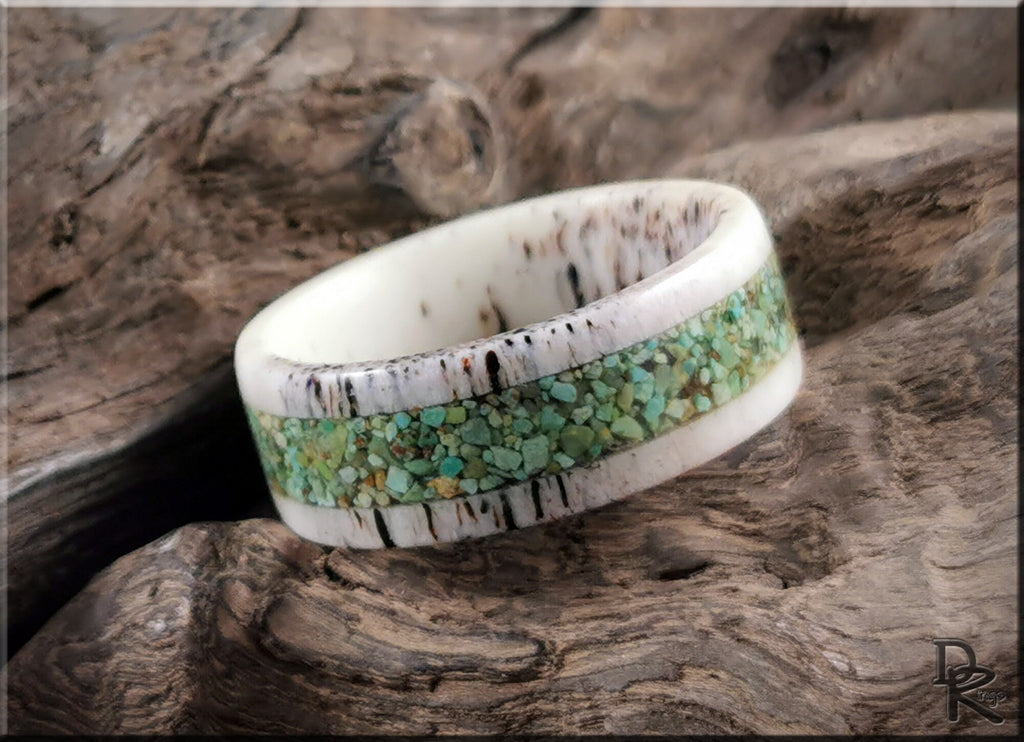 Deer antler ring with turquoise inlay by DR Rings sitting on rustic wood background