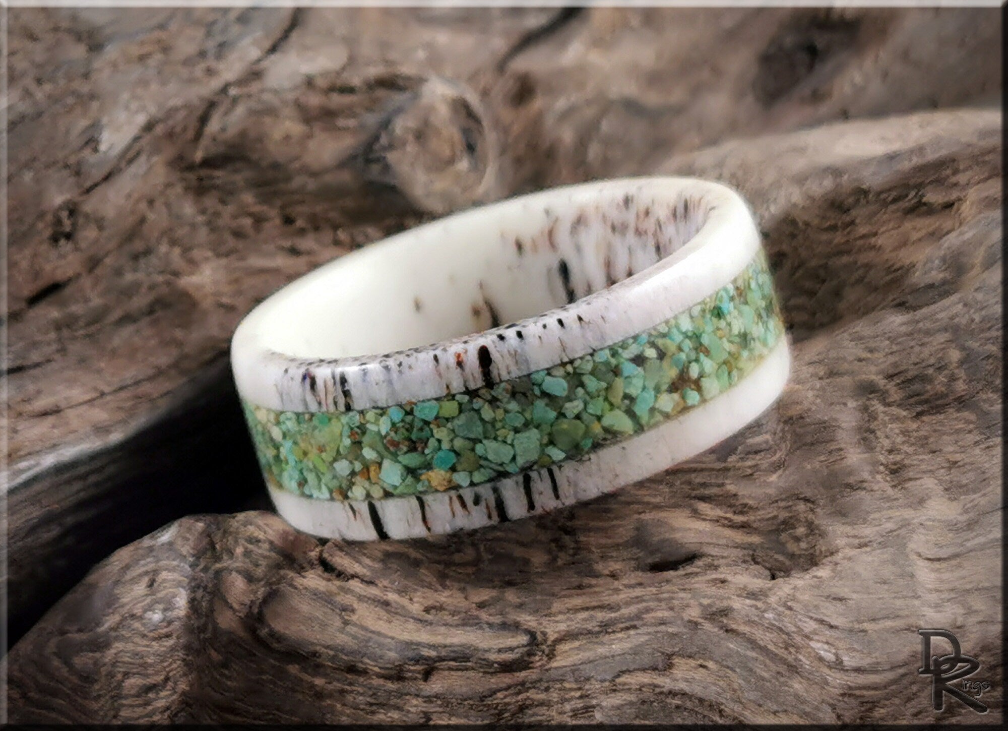 Deer antler ring with turquoise inlay by DR Rings sitting on rustic wood background