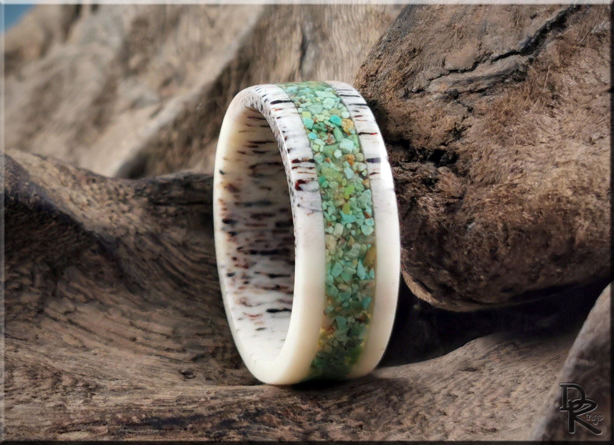 Deer antler ring with turquoise inlay from DR Rings displayed on rustic wood background