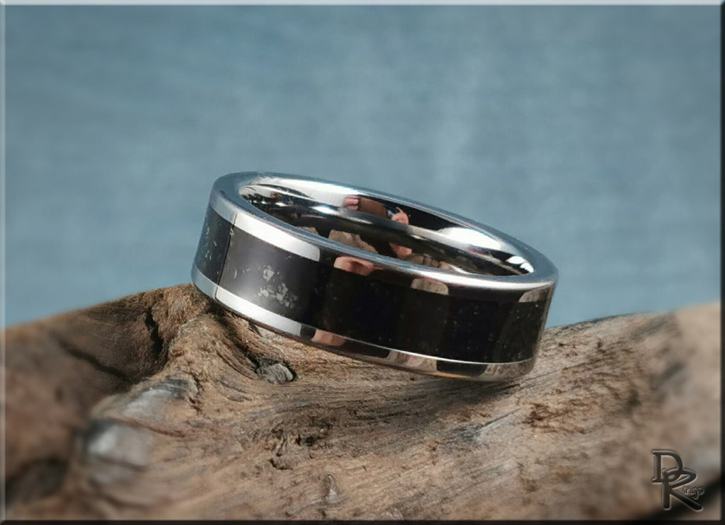 Tungsten ring with shungite black inlay polished silver edges on rustic wood background