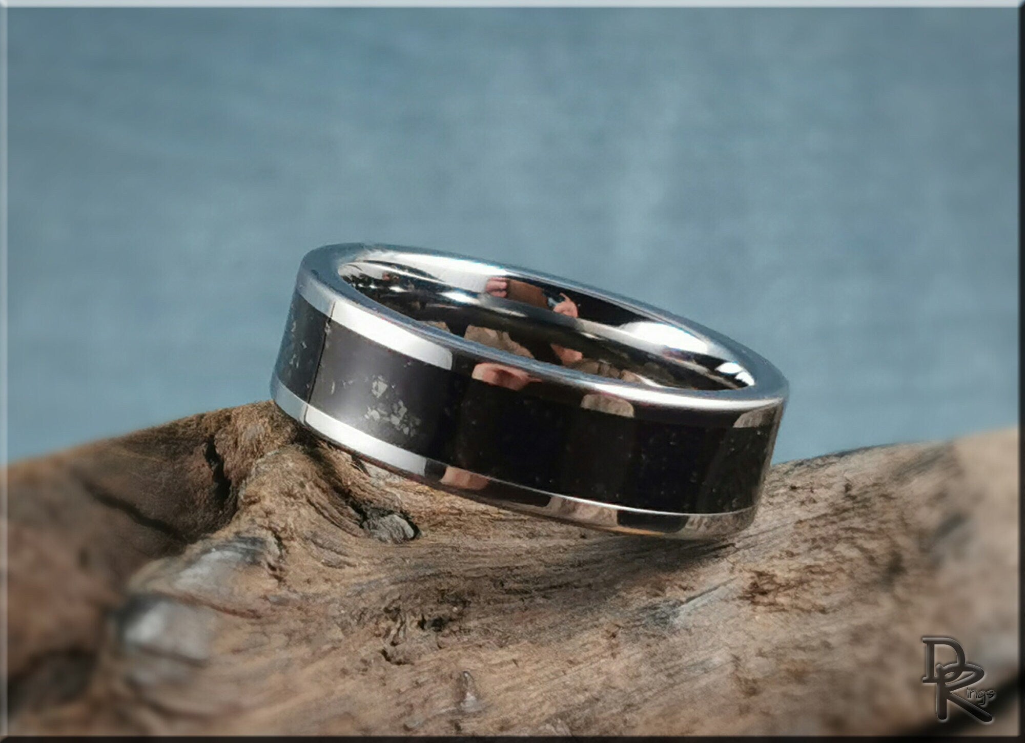 Tungsten ring with shungite black inlay polished silver edges on rustic wood background