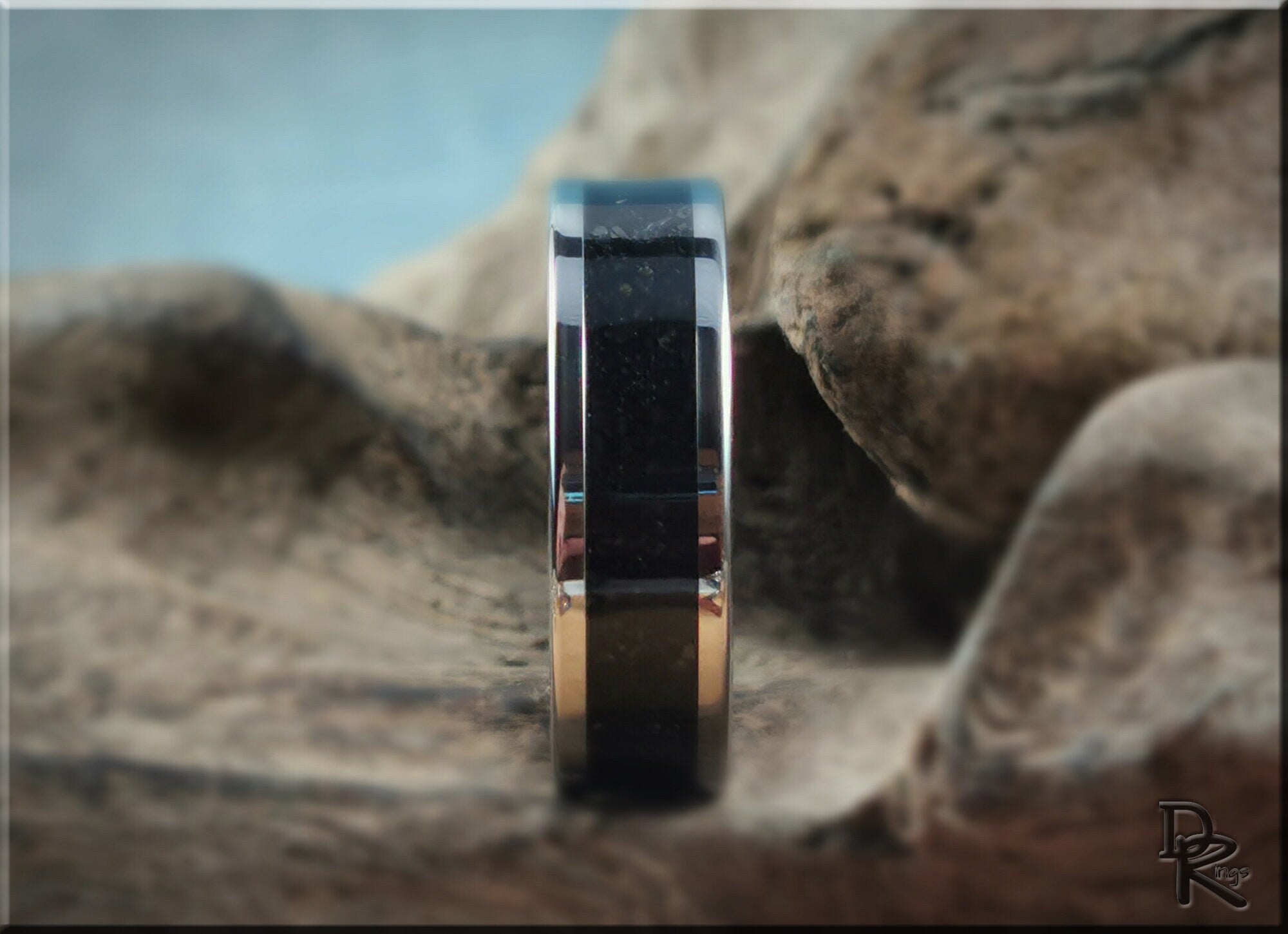 Tungsten ring with shungite center band displayed on natural wooden surface by DR Rings