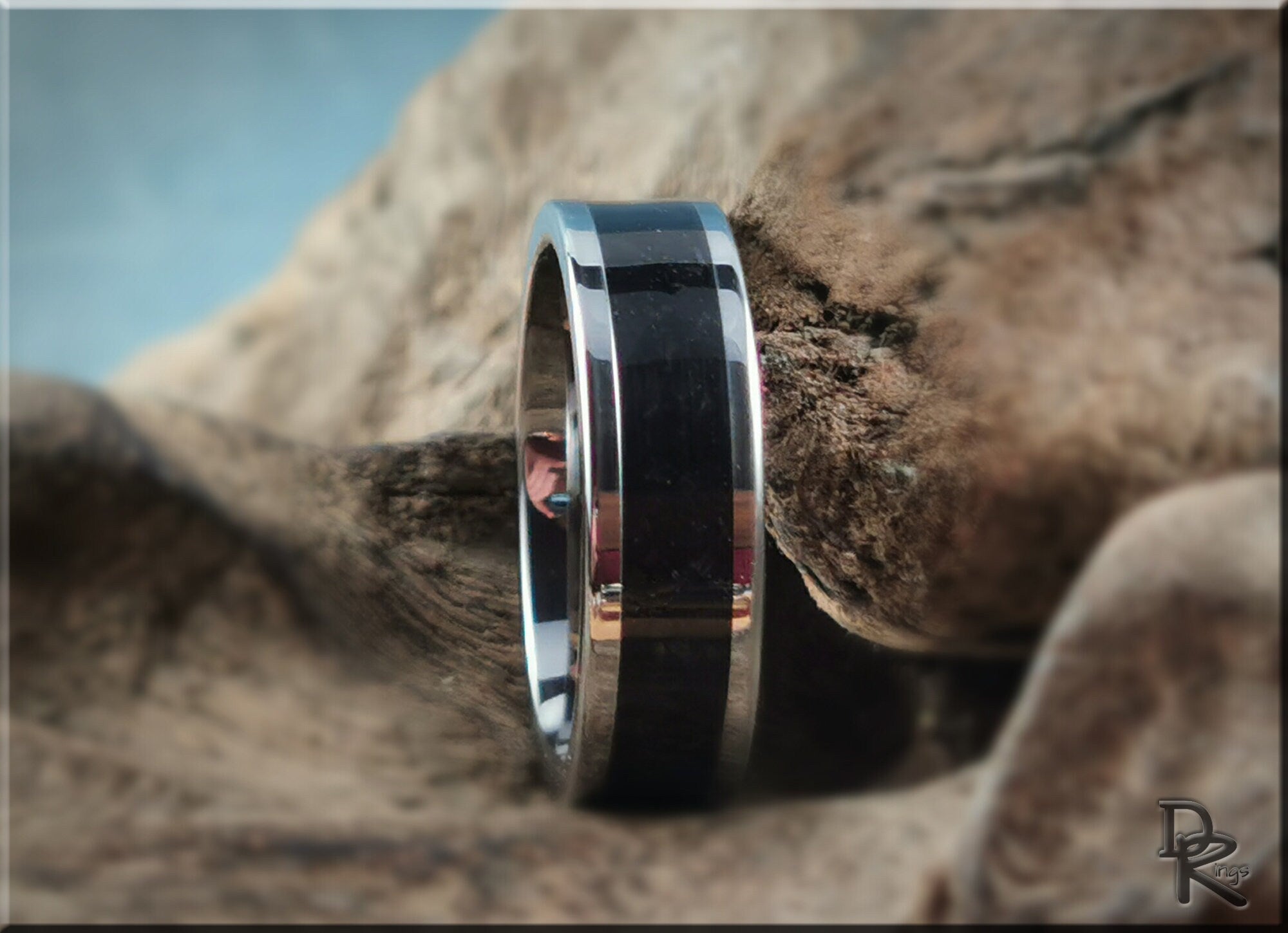 DR Rings tungsten ring with shungite inlay featuring polished silver edges on natural wood background
