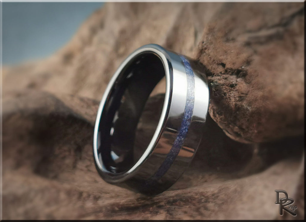 DR Rings black ceramic ring with blue center inlay on textured brown rock background