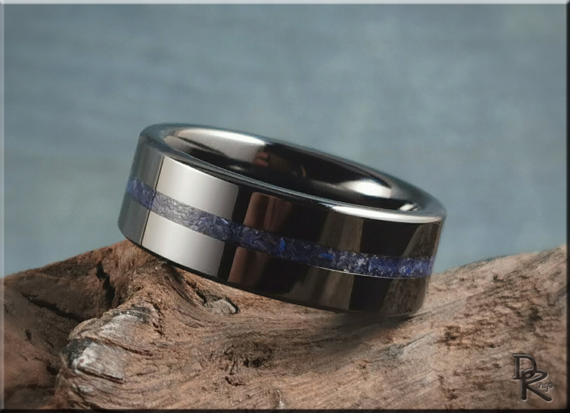 DR Rings black ceramic ring with a blue inlay band on wood background