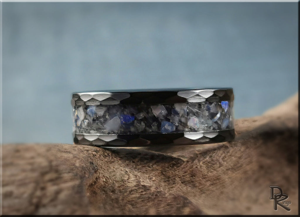 DR Rings hammered ceramic ring with inlay featuring a blue and gray textured design on a natural wood background