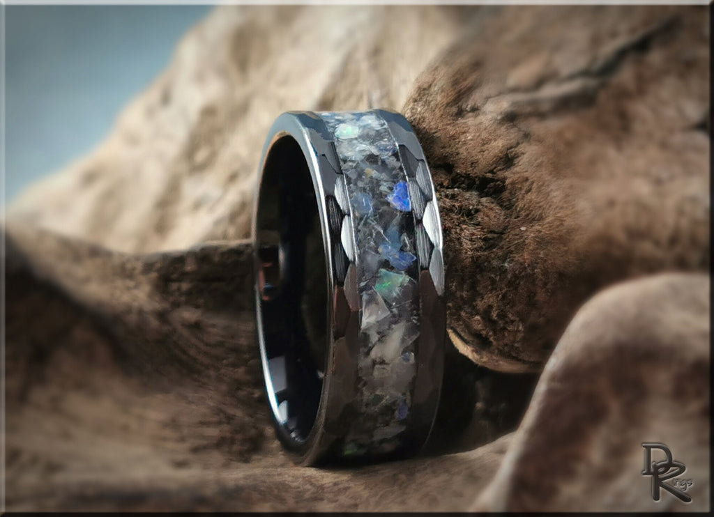 Hammered ceramic ring with inlay featuring a glossy black band and multicolored stone accents