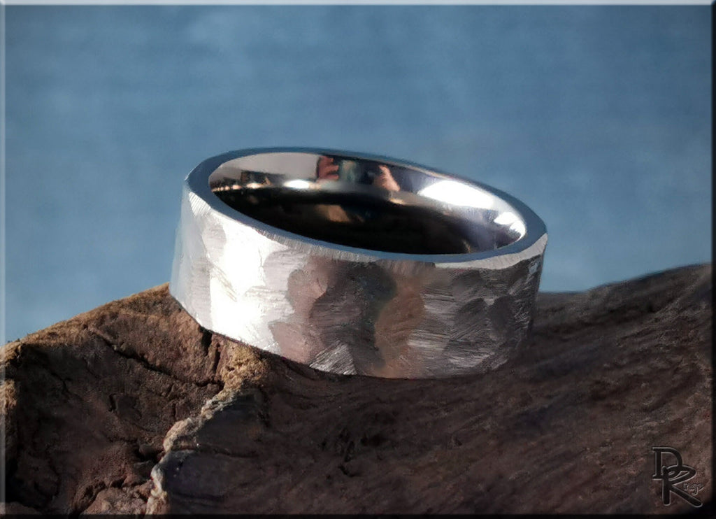 DR Rings hammered titanium ring with textured surface on a rustic wooden background