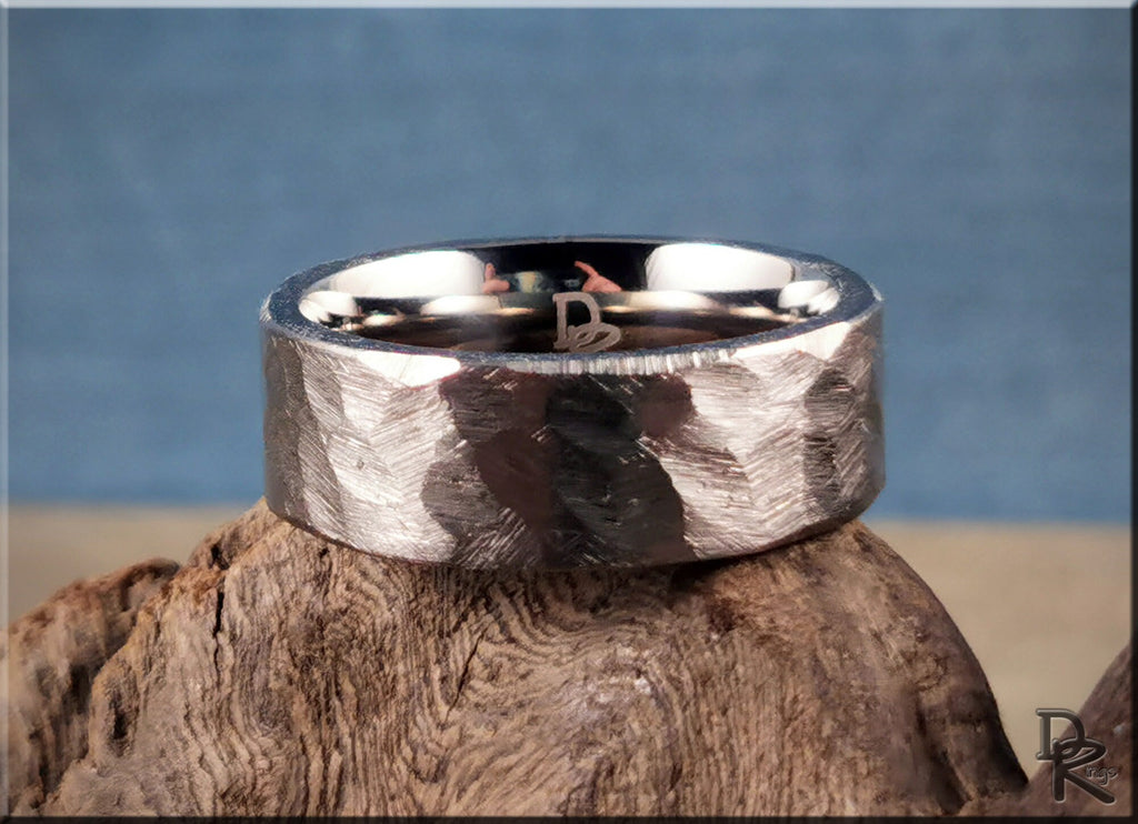 Hammered titanium ring by DR Rings with textured finish on rustic wooden surface