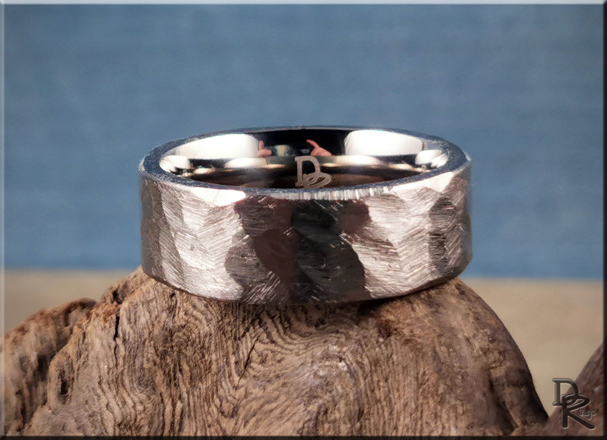 Hammered titanium ring by DR Rings with textured finish on rustic wooden surface