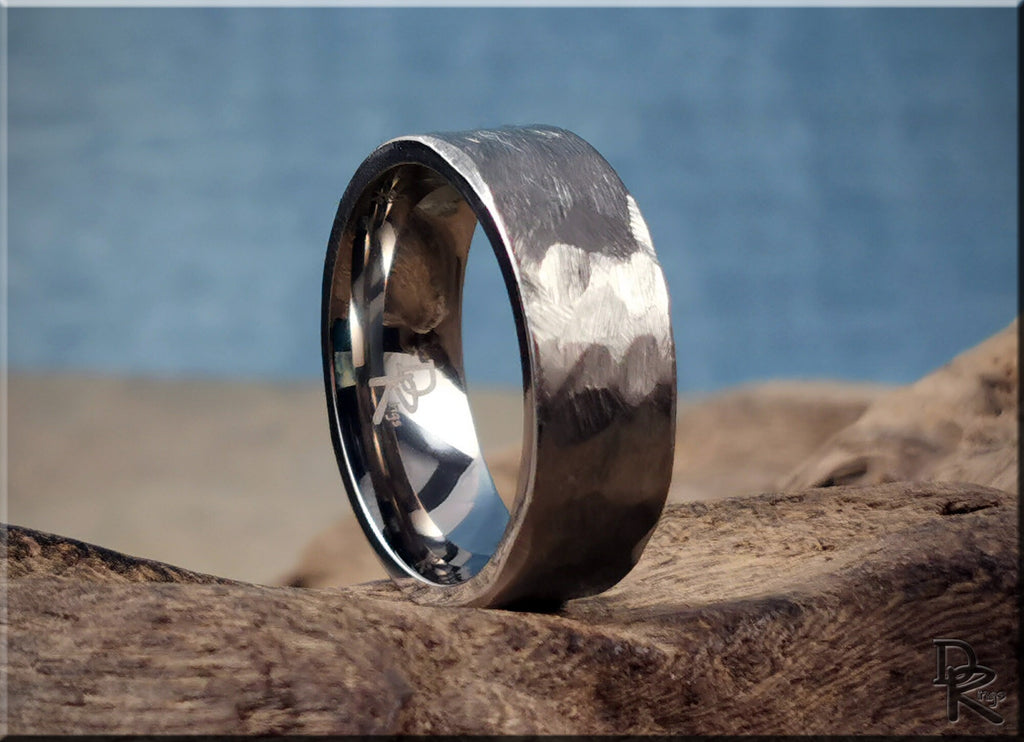 Hammered titanium ring with textured surface on rustic wood background by DR Rings