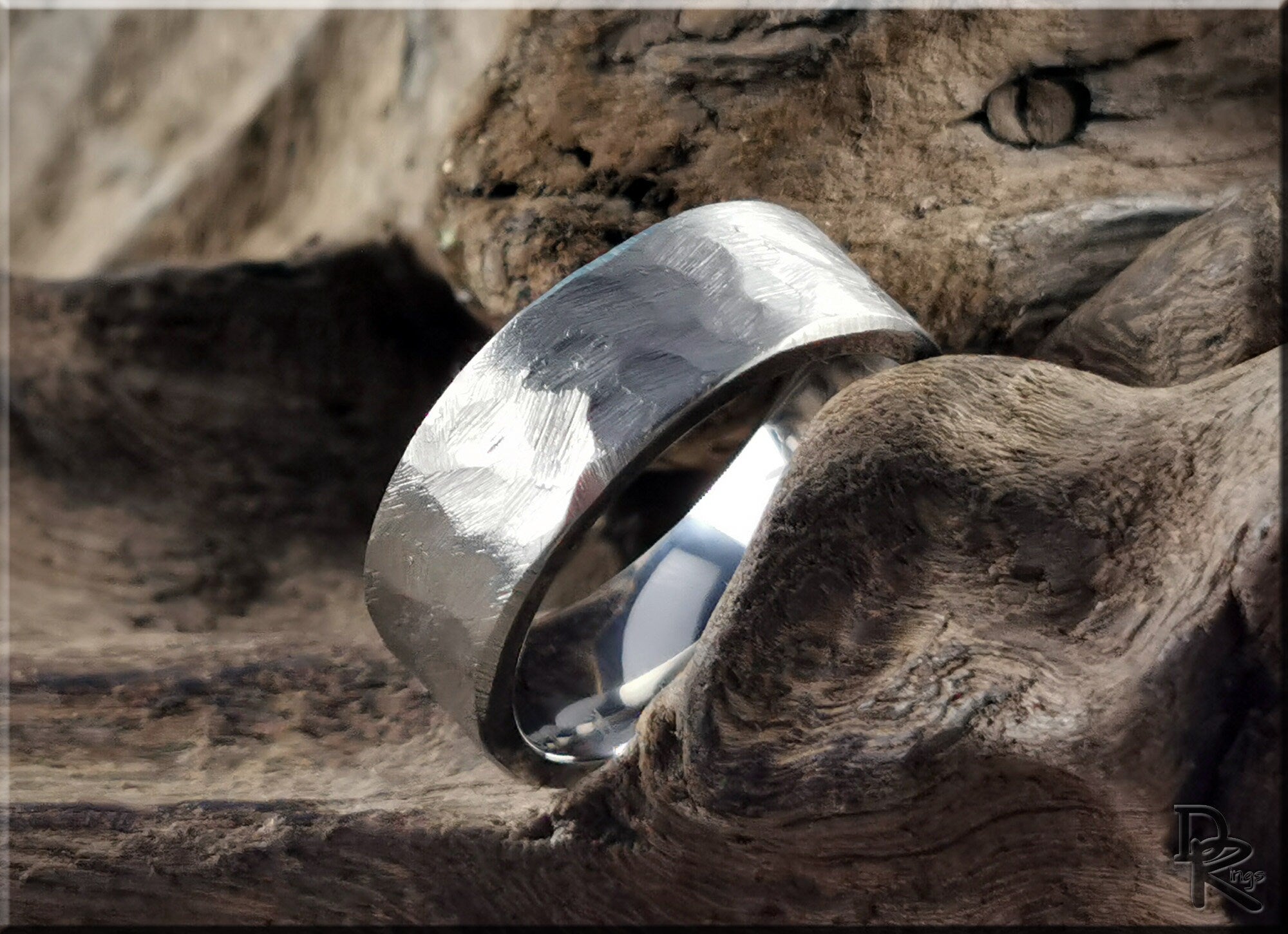 Hammered titanium ring with a textured finish displayed on rustic wood background by DR Rings