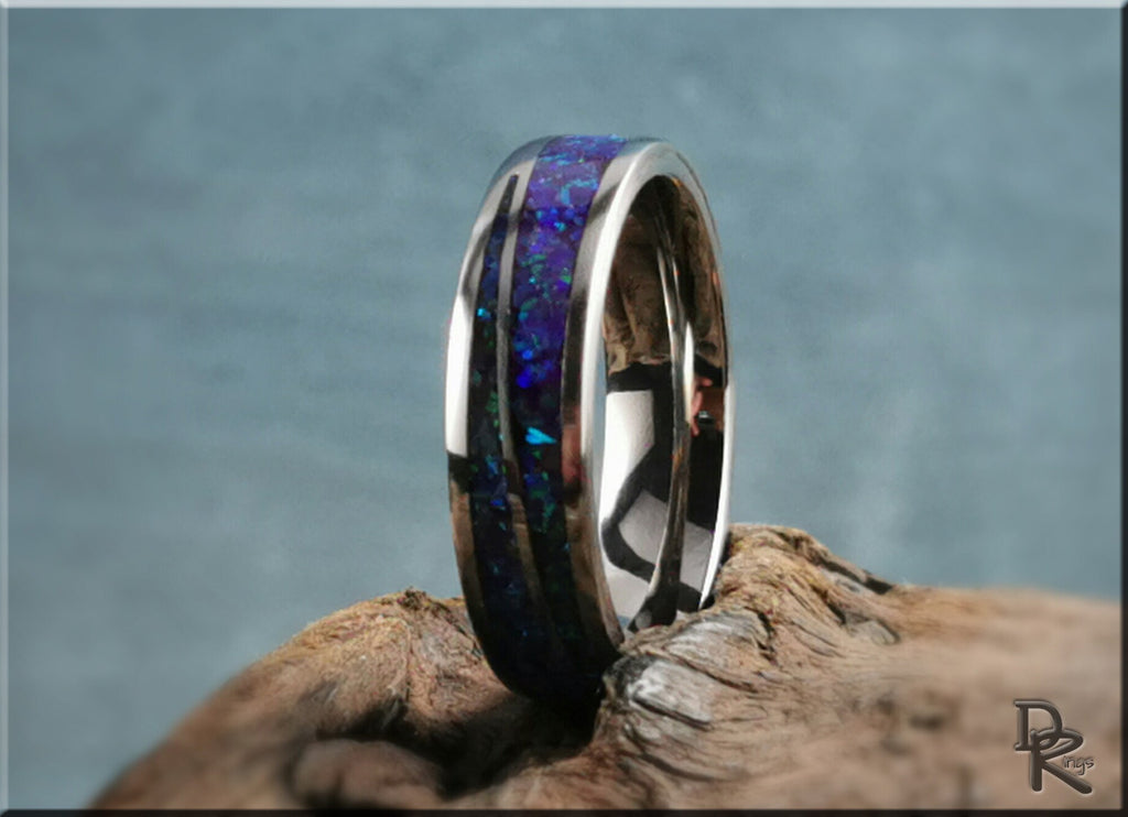 DR Rings polished titanium ring with opal inlay featuring vibrant blue and purple hues on rustic wood